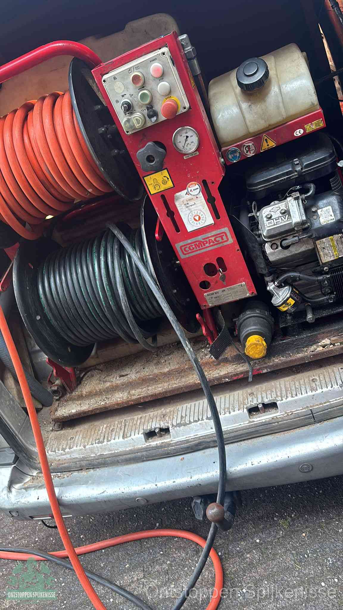 Een rood hogedruk-rioolreinigingstoestel in de laadbak van de bedrijfsbus, apparatuur voor een hardnekkige afvoerverstopping in Spijkenisse