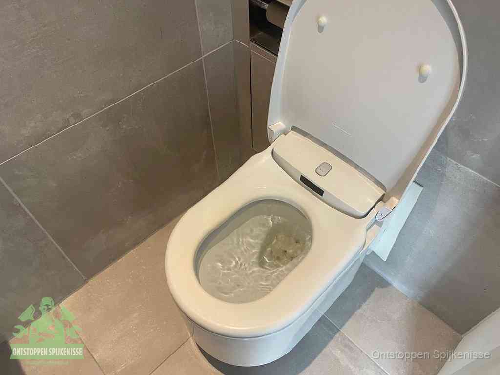 Een toiletpot vol troebel water met drijvend papier en restanten, de meest voorkomende oorzaak van een verstopte wc in Spijkenisse
