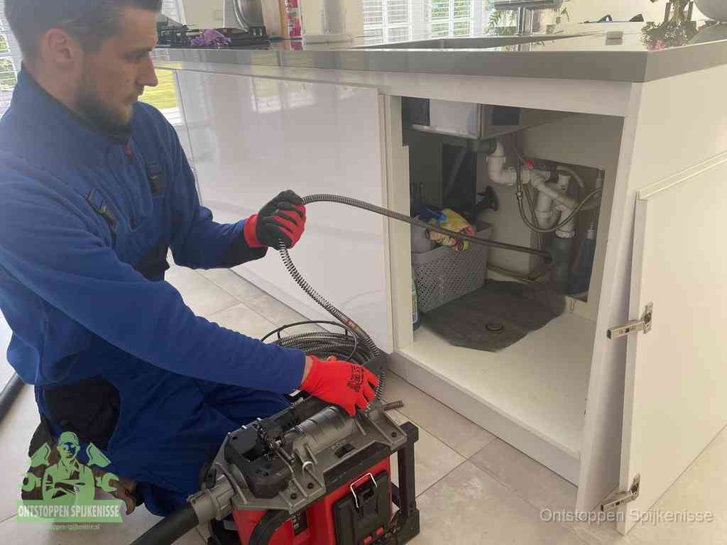 Een monteur reinigt de keukenafvoer grondig met een veermachine om terugkerende gootsteenverstoppingen te voorkomen in Spijkenisse